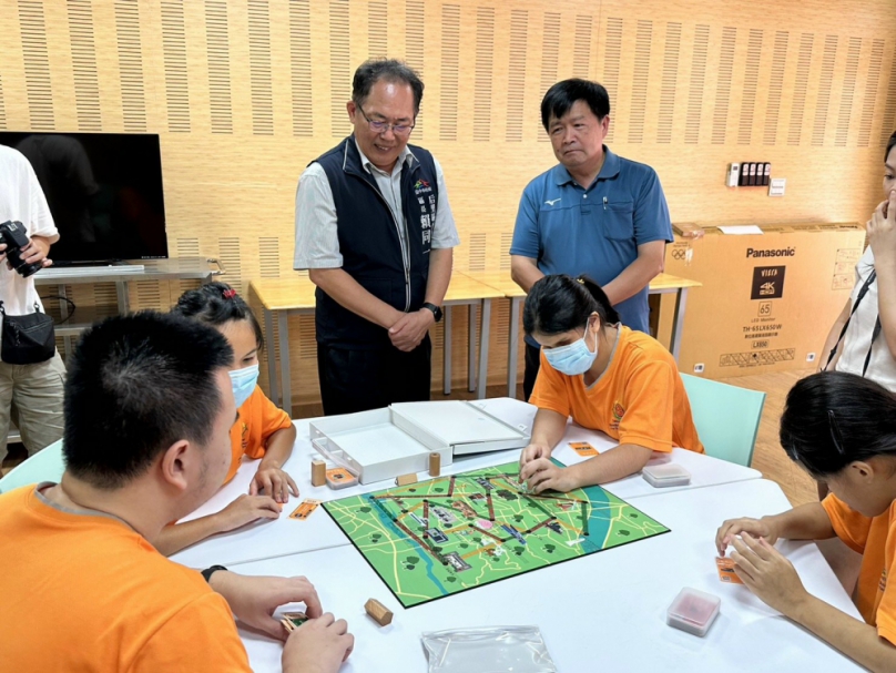 青年何懿庭精心創作出一套視障桌遊  今年延伸到實地景點  后里區長賴同一陪同啟明學校學生  來場看不見的旅行