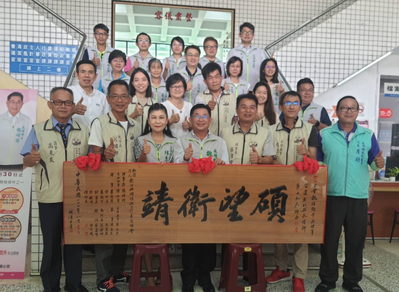 「好德做工行善團」頒贈﹁碩望衛靖﹂匾額給永靖鄉長魏碩衛，公所各課室主管與有榮焉。（照片記者周為政攝）