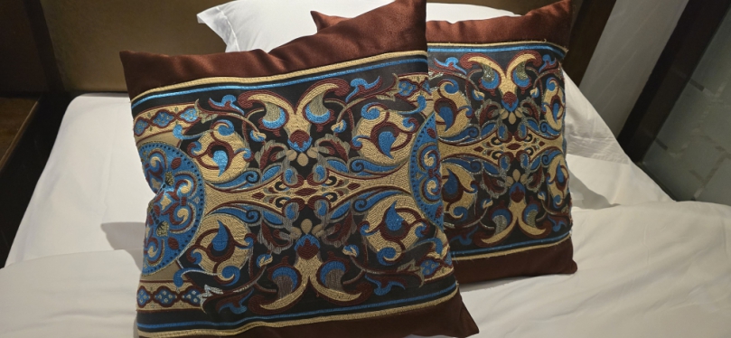 你住飯店時、是否也曾注意到床上那個看似裝飾用的四方型抱枕？多數人以為它是用來抱睡或增添擺設、但其實它的「正職」是用來墊高腳底！