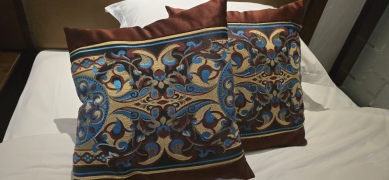 你住飯店時、是否也曾注意到床上那個看似裝飾用的四方型抱枕？多數人以為它是用來抱睡或增添擺設、但其實它的「正職」是用來墊高腳底！