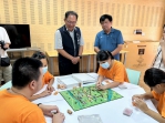 青年何懿庭精心創作出一套視障桌遊  今年延伸到實地景點  后里區長賴同一陪同啟明學校學生  來場看不見的旅行